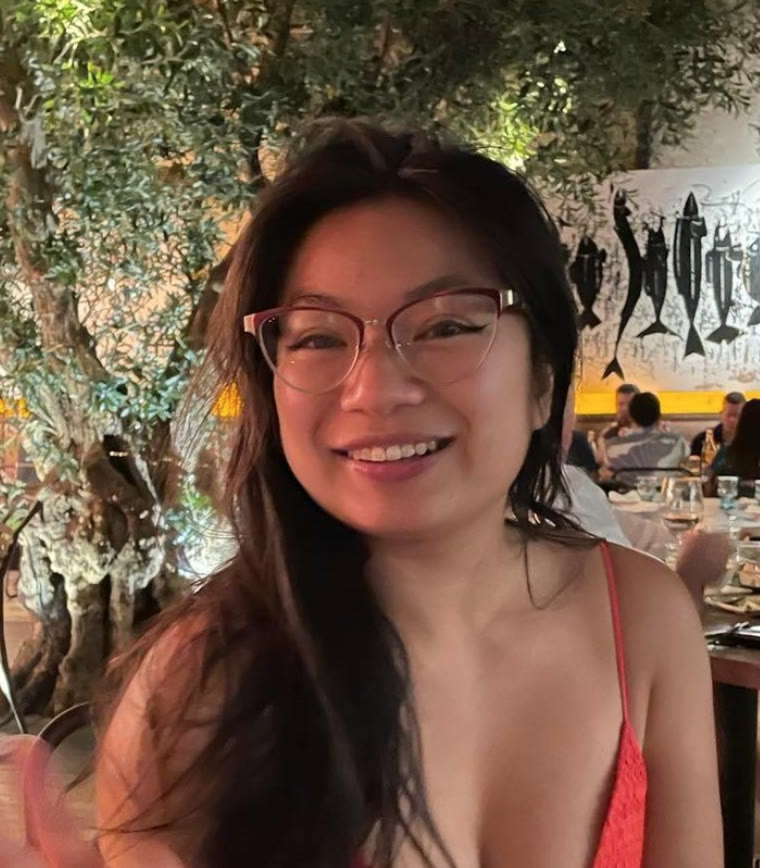 Holly, mid-smile at dinner under an olive tree